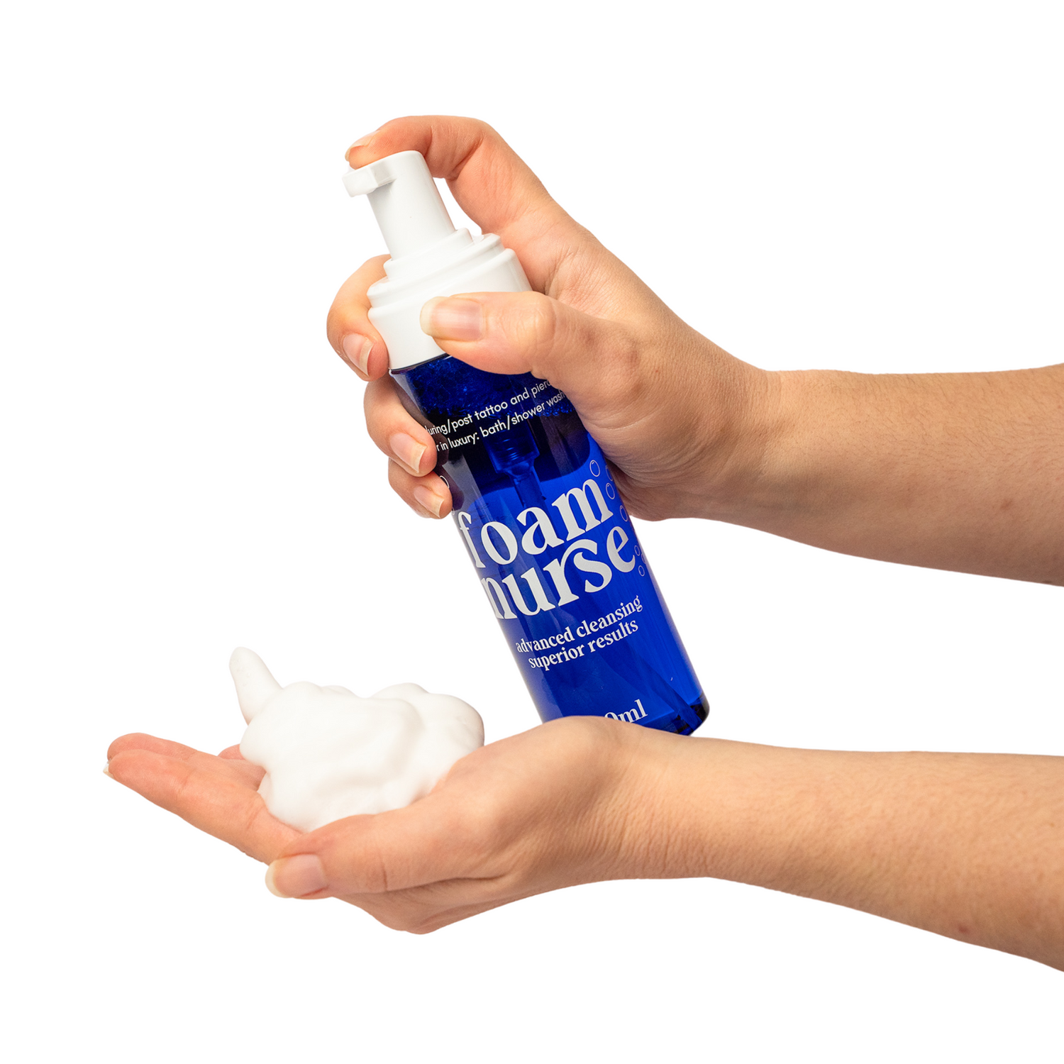Hand holding a blue bottle labeled 'Foam Nurse' with foam on a white background, made by ink nurse tattoo aftercare, the best aftercare in Australia, this foam wash is perfect to clean a fresh, new tattoo